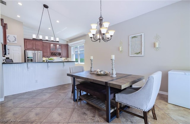 dining space with a notable chandelier, vaulted ceiling, and tile patterned floors