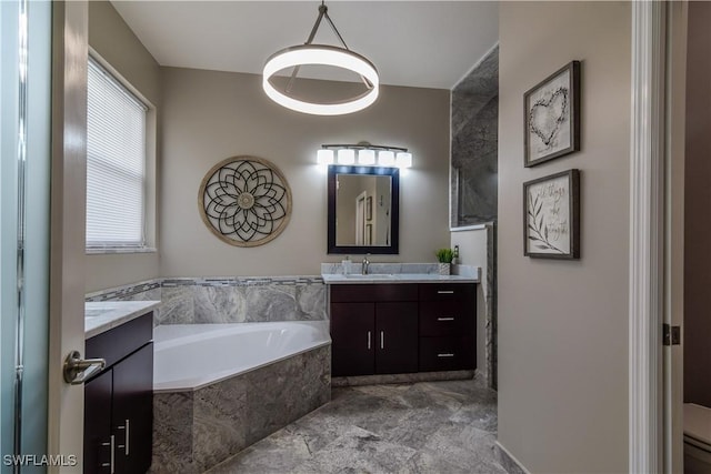 bathroom with vanity and tiled bath