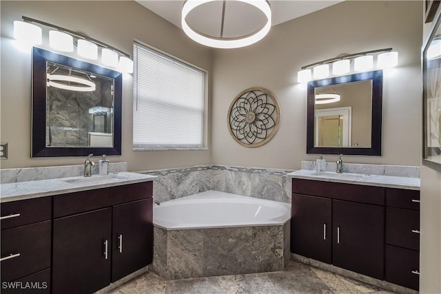 bathroom featuring vanity and tiled bath