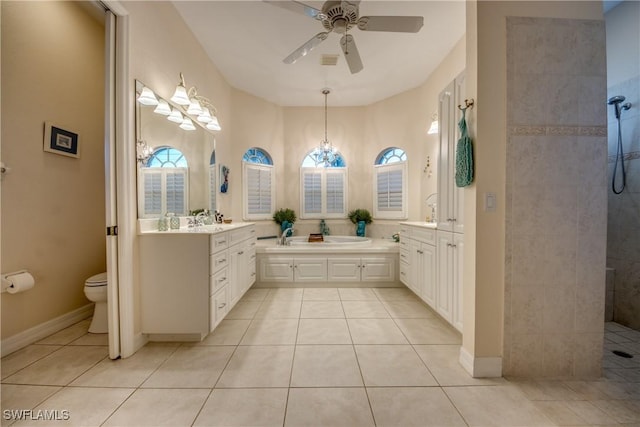 bathroom with toilet, ceiling fan, tile patterned flooring, vanity, and a walk in shower