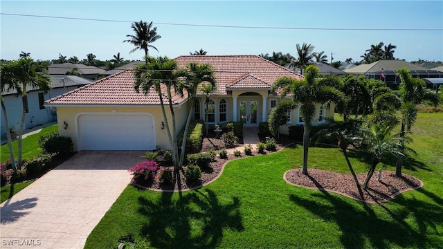 mediterranean / spanish house featuring a tiled roof, an attached garage, decorative driveway, a front yard, and stucco siding