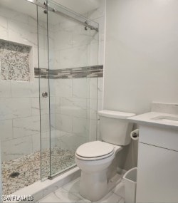 full bathroom with marble finish floor, a stall shower, vanity, and toilet