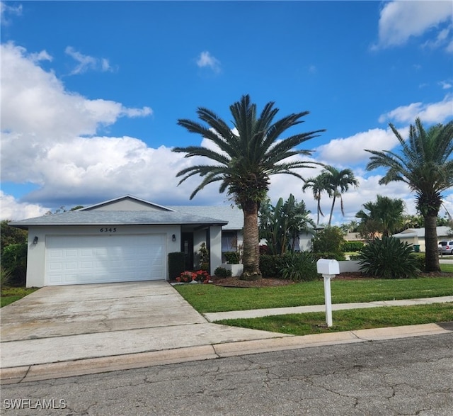 ranch-style home with a front yard, concrete driveway, an attached garage, and stucco siding