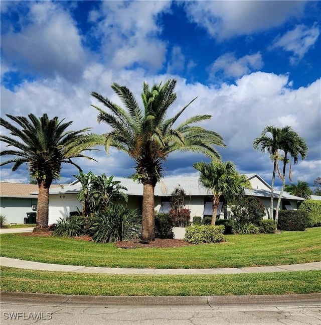 view of side of property with a garage and a lawn