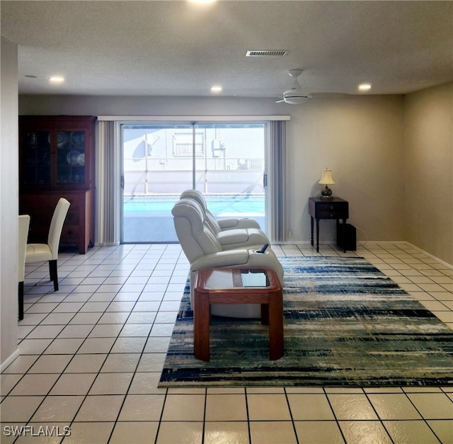 living area with a ceiling fan, recessed lighting, visible vents, and light tile patterned floors