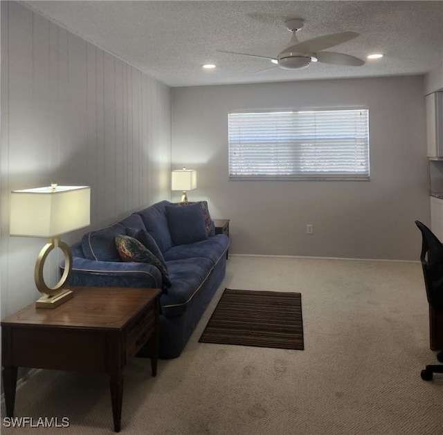 carpeted living room with a ceiling fan and a textured ceiling