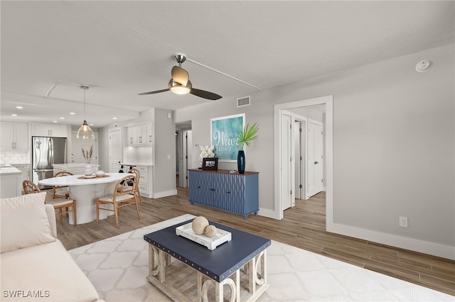 living room with hardwood / wood-style flooring and ceiling fan