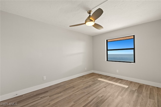 unfurnished room with hardwood / wood-style floors, ceiling fan, and a textured ceiling