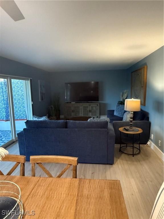 living area featuring baseboards and wood finished floors