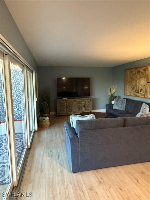 living area with baseboards and wood finished floors