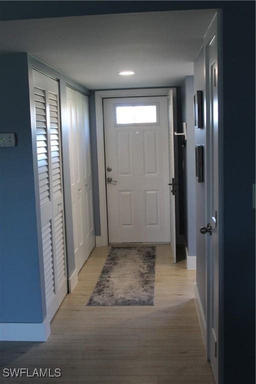 doorway to outside featuring light wood-type flooring and baseboards