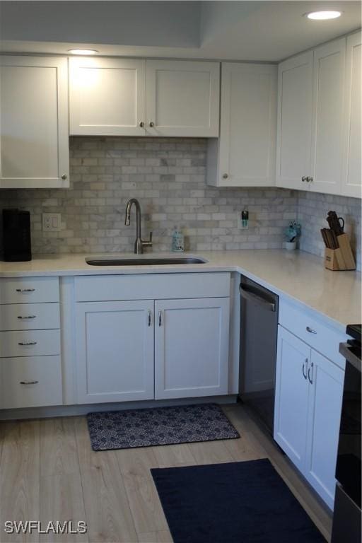 kitchen featuring a sink, white cabinetry, light wood-style floors, light countertops, and dishwasher