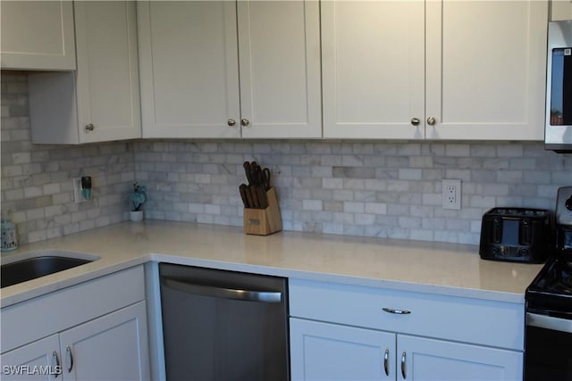 kitchen featuring stainless steel appliances, white cabinetry, and decorative backsplash