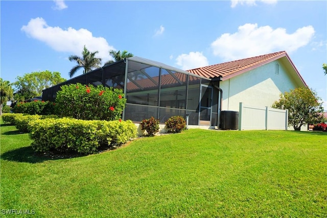 back of property featuring a yard, a lanai, and stucco siding