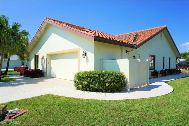 view of property exterior featuring stucco siding, a lawn, an attached garage, driveway, and a tiled roof