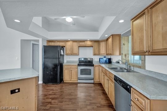 kitchen with sink, ceiling fan, dark hardwood / wood-style floors, black appliances, and a raised ceiling