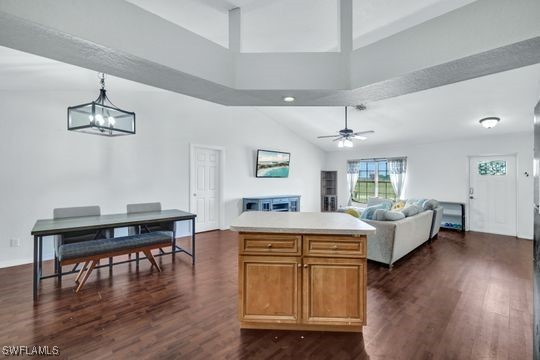 kitchen with ceiling fan, dark hardwood / wood-style floors, a center island, and hanging light fixtures