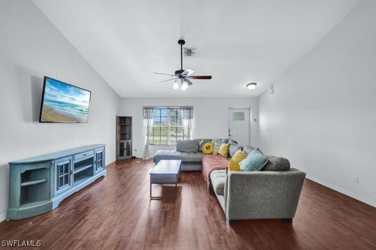 living room with lofted ceiling, dark wood-type flooring, and ceiling fan