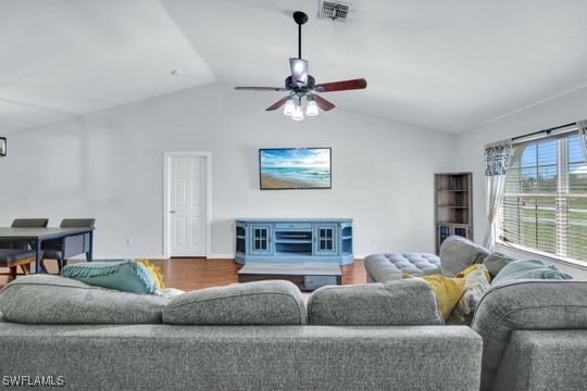 living room featuring hardwood / wood-style flooring, ceiling fan, and lofted ceiling