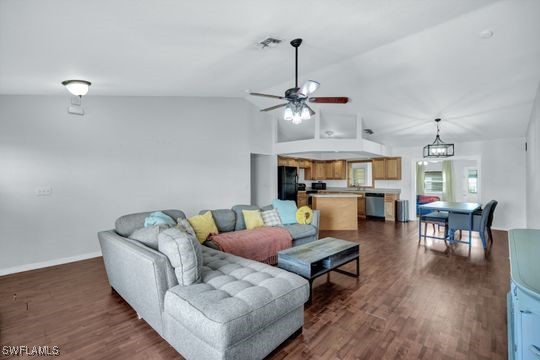 living room featuring lofted ceiling, dark hardwood / wood-style floors, and ceiling fan