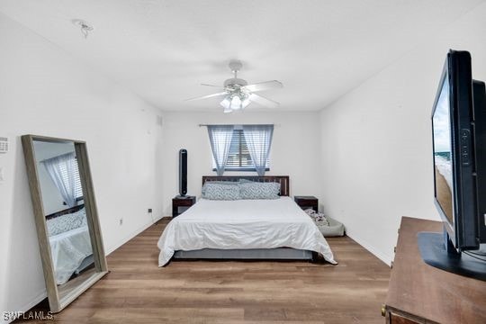 bedroom with ceiling fan and wood-type flooring