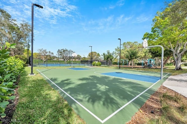 view of sport court with playground community, community basketball court, and fence