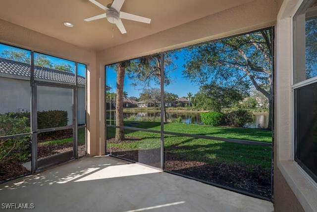 unfurnished sunroom featuring a water view and ceiling fan