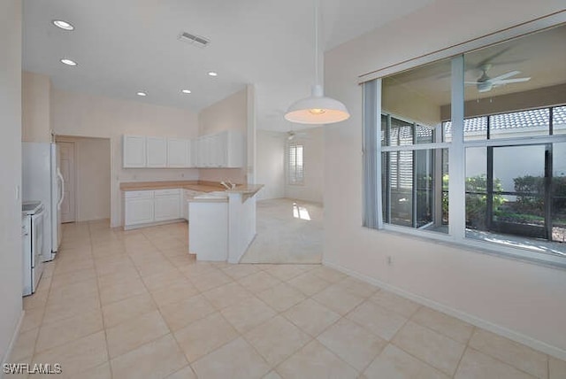 kitchen featuring a peninsula, stove, light countertops, white cabinetry, and open floor plan