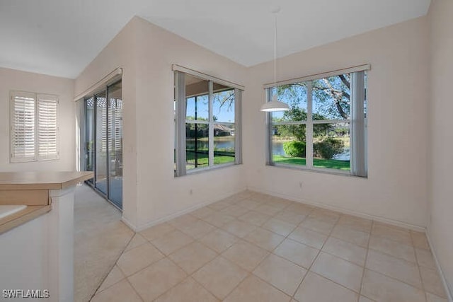 unfurnished dining area with light tile patterned floors and baseboards