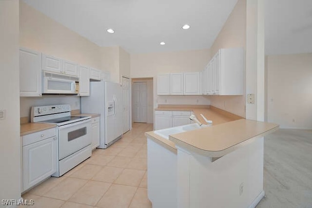 kitchen with white appliances, a peninsula, a sink, light countertops, and white cabinets