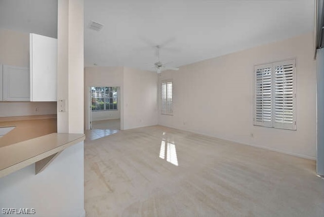 empty room with wood finished floors, visible vents, and ceiling fan