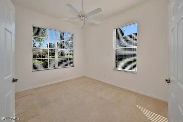 spare room featuring carpet flooring, baseboards, and ceiling fan