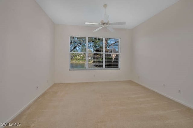 empty room featuring baseboards, light colored carpet, and ceiling fan