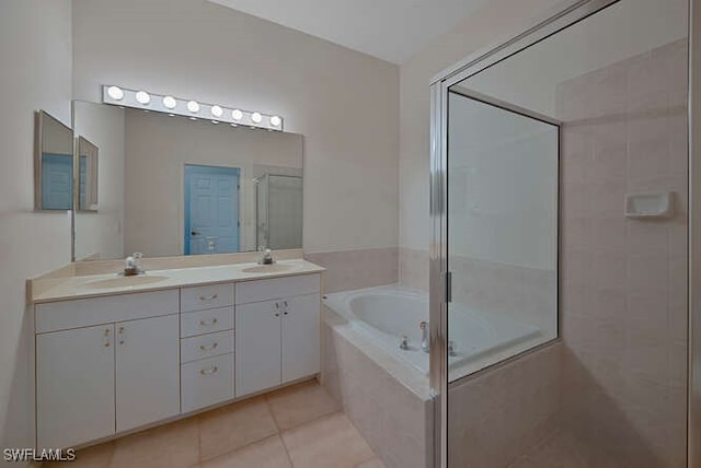 bathroom featuring tile patterned floors, a shower stall, a bath, and a sink