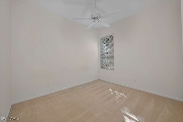 spare room featuring baseboards, light colored carpet, and ceiling fan