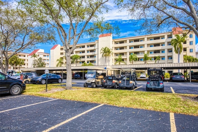 view of property featuring covered and uncovered parking