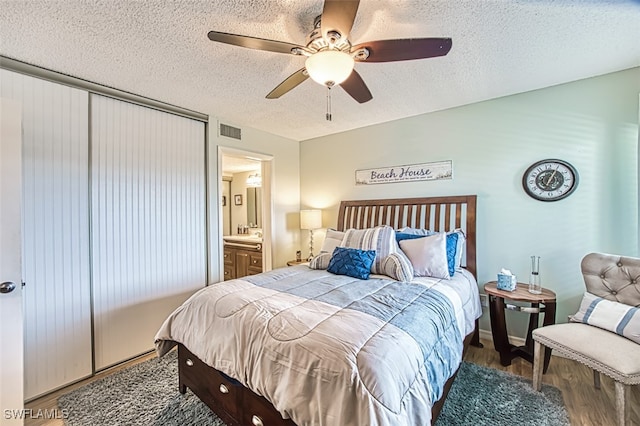 bedroom with visible vents, a textured ceiling, a ceiling fan, and wood finished floors