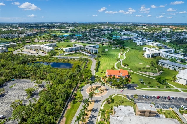 birds eye view of property with view of golf course and a water view