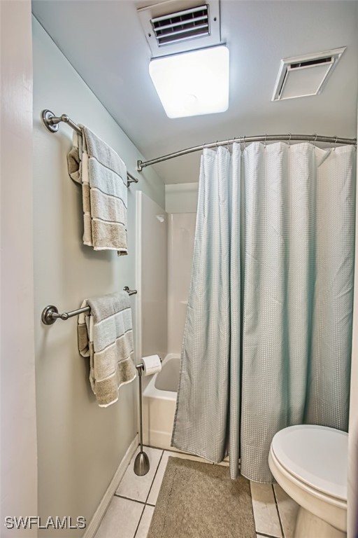 full bathroom with tile patterned floors, visible vents, toilet, and shower / bathtub combination with curtain