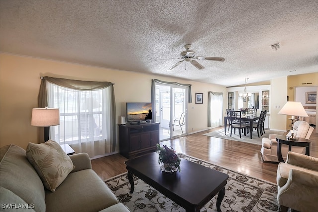 living room featuring hardwood / wood-style flooring, ceiling fan with notable chandelier, and a textured ceiling