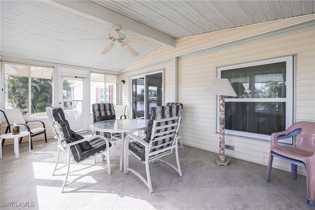 sunroom with lofted ceiling with beams and ceiling fan