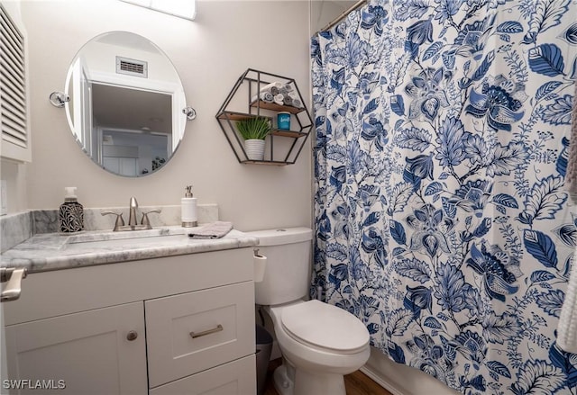 bathroom with toilet, visible vents, and vanity