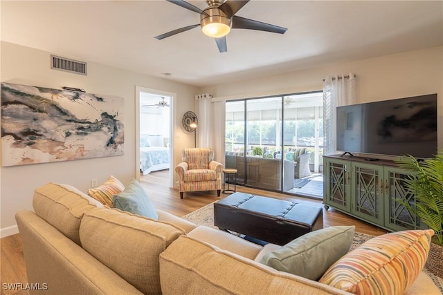 living room with ceiling fan, baseboards, visible vents, and light wood-style floors