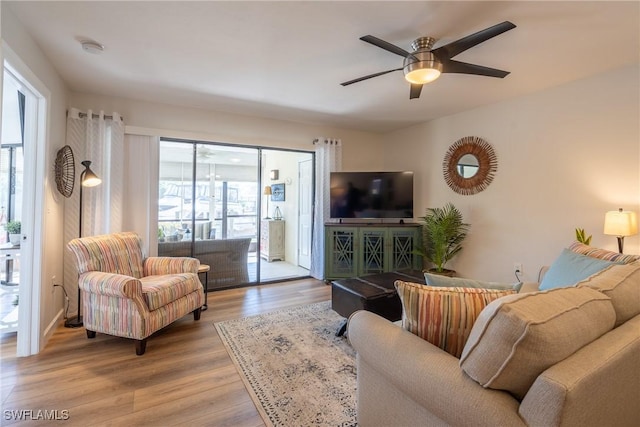 living room featuring light wood finished floors and a ceiling fan