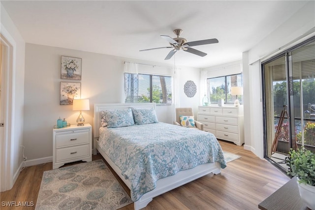 bedroom featuring access to outside, baseboards, light wood-style flooring, and a ceiling fan