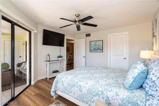 bedroom featuring access to outside, visible vents, baseboards, and wood finished floors