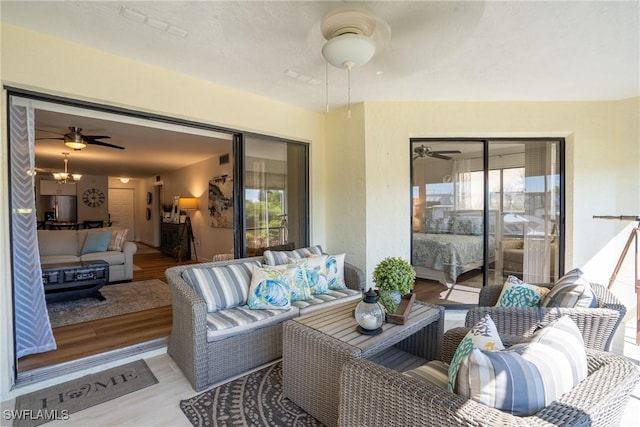 interior space with light wood-style floors, a wealth of natural light, and ceiling fan with notable chandelier