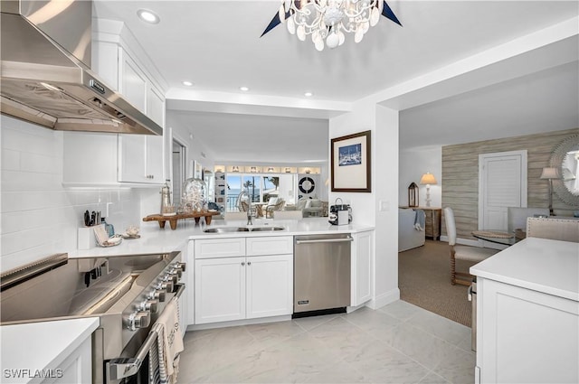 kitchen featuring sink, wall chimney exhaust hood, stainless steel appliances, and white cabinets