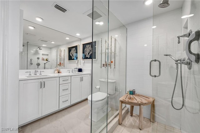 bathroom with toilet, vanity, and a shower with shower door