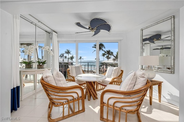 sunroom featuring a water view and ceiling fan